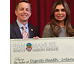 Representatives from both groups hold up a check showing the amount of the grant.