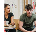 A group of young people sit in a circle in a group therapy scenario