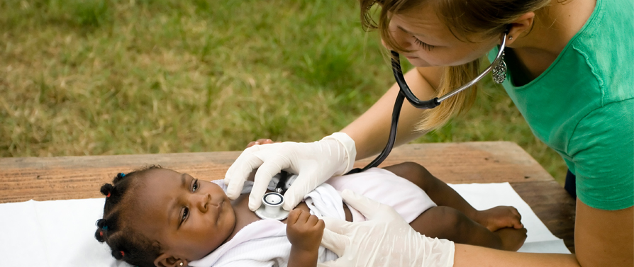 child getting her heart checked by doctor